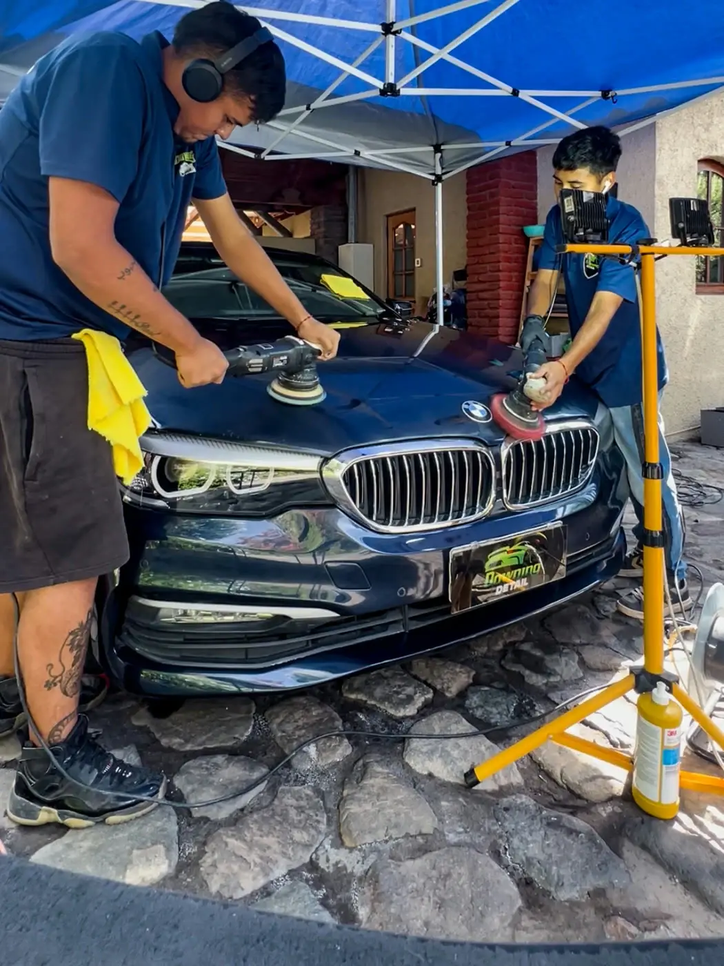 Técnicos de Downing Detail puliendo un BMW Serie 5
